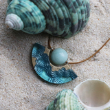 Reef curved beach necklace on sand with shells