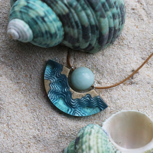 Reef curved beach necklace on sand with shells